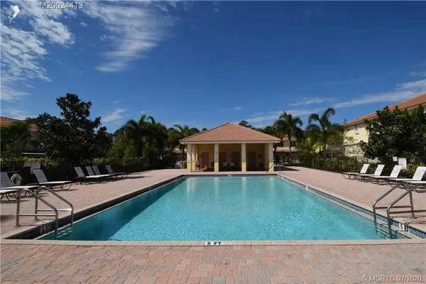 a view of a house with pool fire pit tables and chairs