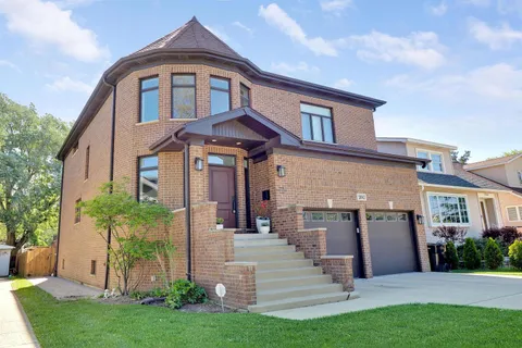 a front view of a house with a garden and plants