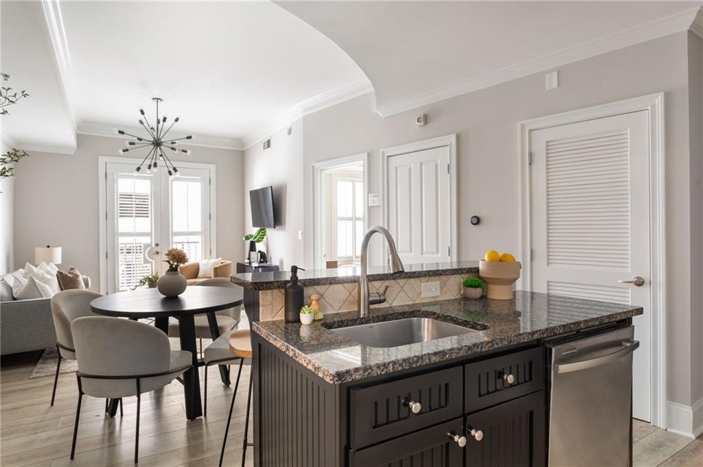 2255 Peachtree Road Northeast, Unit 326 Atlanta, GA 30309 - Photo 8 of 37 a dining hall with stainless steel appliances granite countertop a sink dishwasher a dining table and chairs with wooden floor
