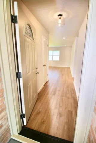 a view of a hallway with wooden floor and staircase