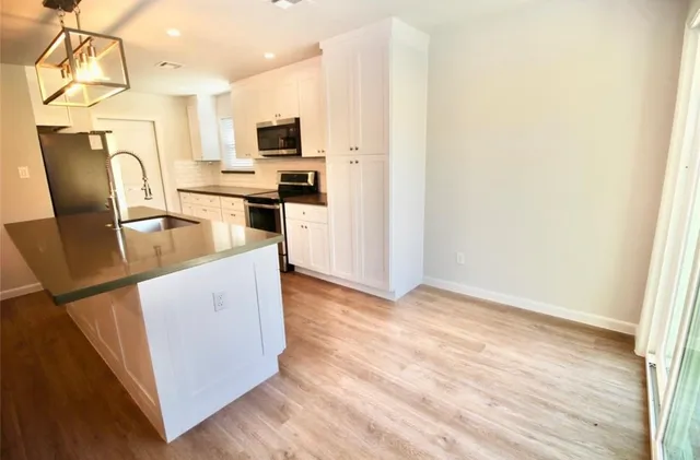 a kitchen with stainless steel appliances a refrigerator stove microwave and sink