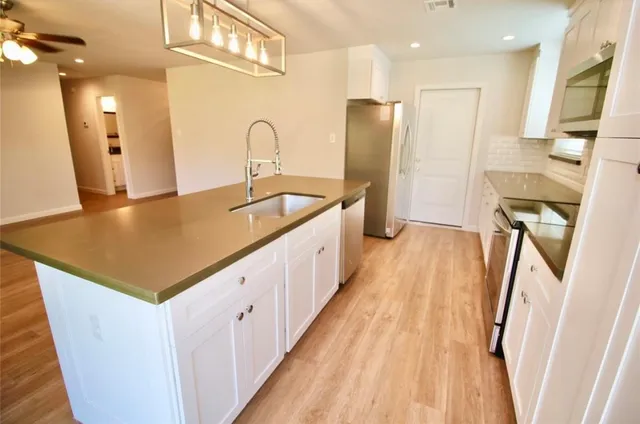a spacious bathroom with a sink a mirror and shower