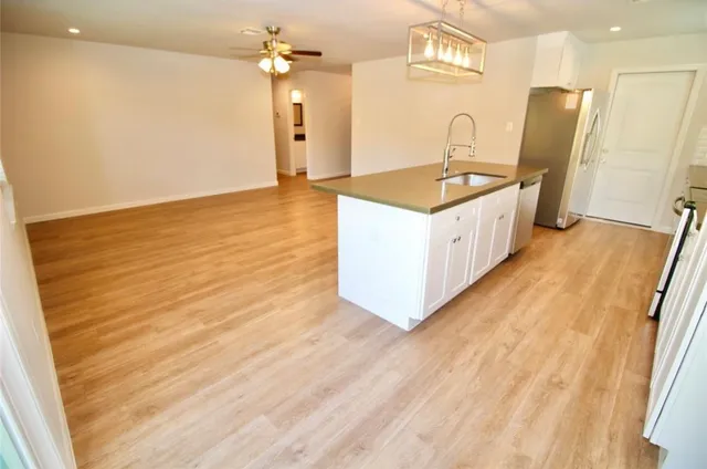a spacious bathroom with a granite countertop sink a mirror and a shower