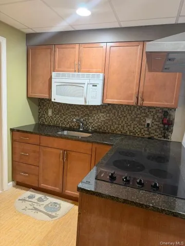 a kitchen with granite countertop a sink and a stove