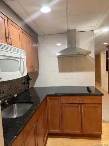 a kitchen with granite countertop a sink and a stove