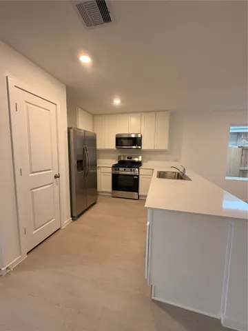 a kitchen with refrigerator and cabinets