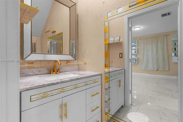 a bathroom with a granite countertop sink and a mirror