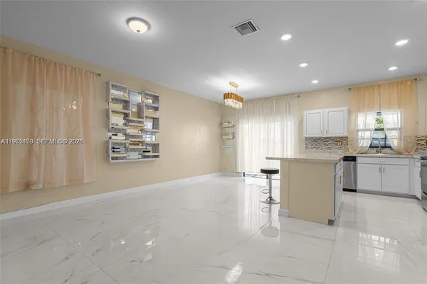 a large white kitchen with white cabinets and stainless steel appliances