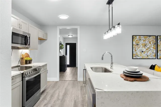 a kitchen with stainless steel appliances a stove a sink and a refrigerator