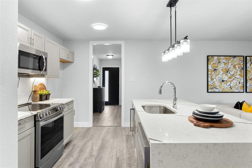 5405 Ramsey Drive The Colony, TX 75056 - Photo 11 of 32 a kitchen with stainless steel appliances a stove a sink and a refrigerator