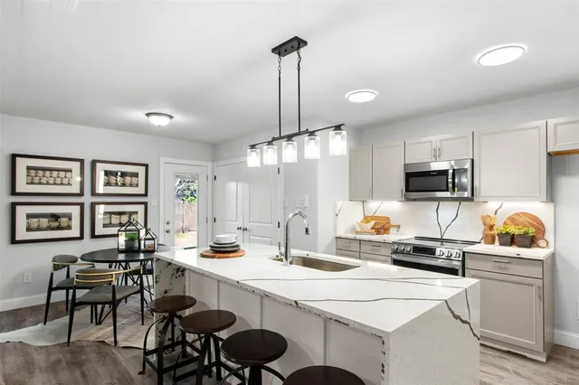 a kitchen with a dining table chairs refrigerator and sink