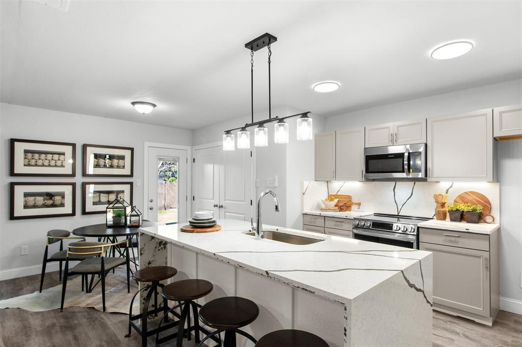 5405 Ramsey Drive The Colony, TX 75056 - Photo 12 of 32 a kitchen with a dining table chairs refrigerator and sink