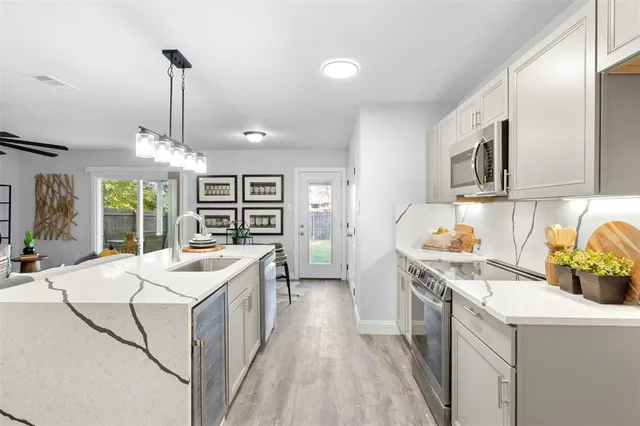 a kitchen that has a sink a stove and a wooden floors