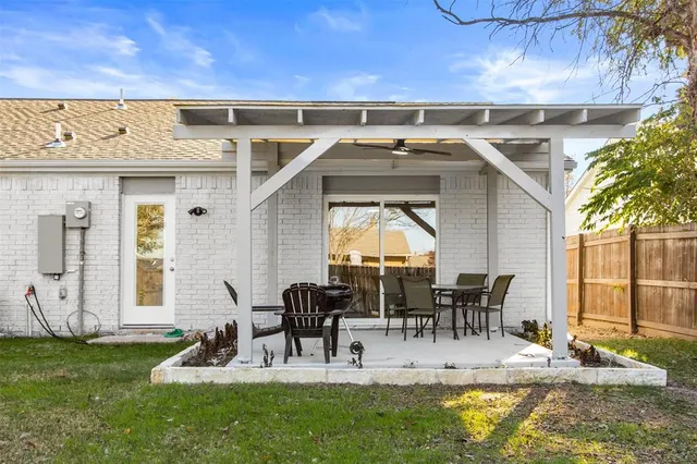 a view of a patio with table and chairs potted plants and large tree
