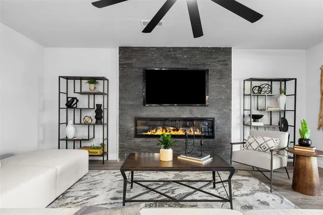 a living room with furniture a fireplace and a flat screen tv
