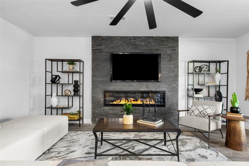 5405 Ramsey Drive The Colony, TX 75056 - Photo 4 of 32 a living room with furniture a fireplace and a flat screen tv