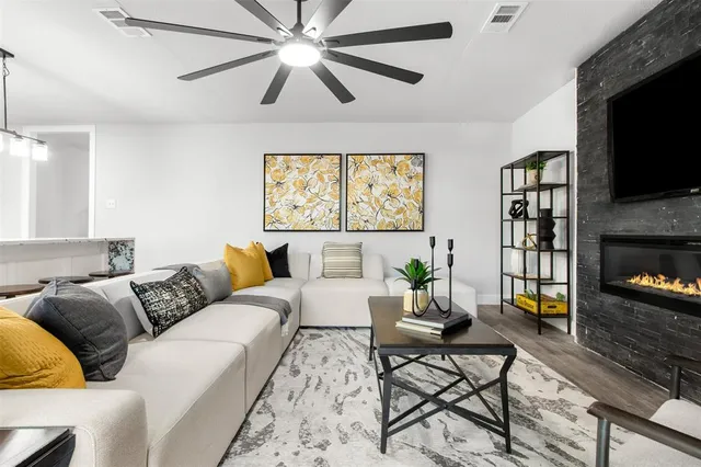 a living room with furniture a flat screen tv and a fireplace