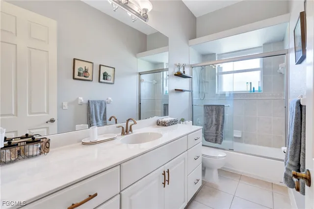 a bathroom with a granite countertop sink mirror toilet and bathtub