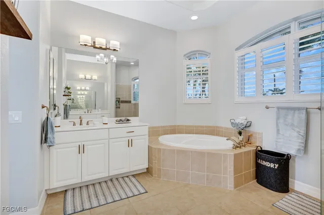 a bathroom with a tub sink and mirror