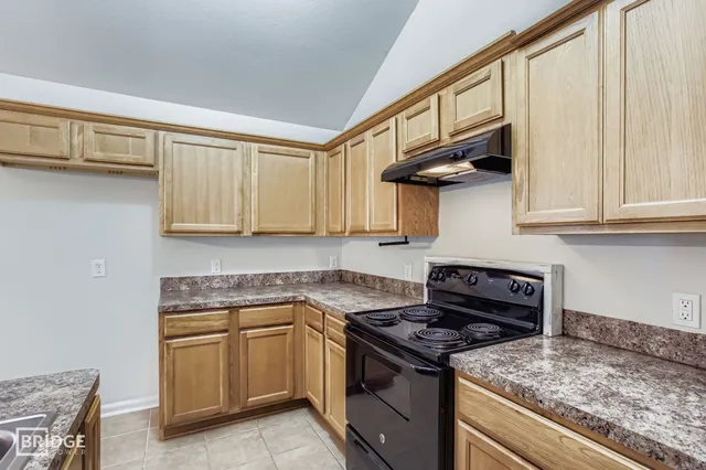 a kitchen with stainless steel appliances granite countertop a stove and a white cabinets