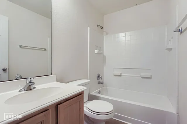 a bathroom with a sink toilet vanity and shower