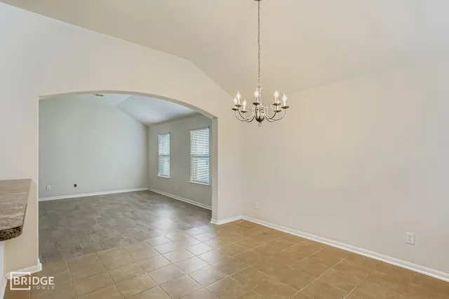 a view of an empty room with chandelier