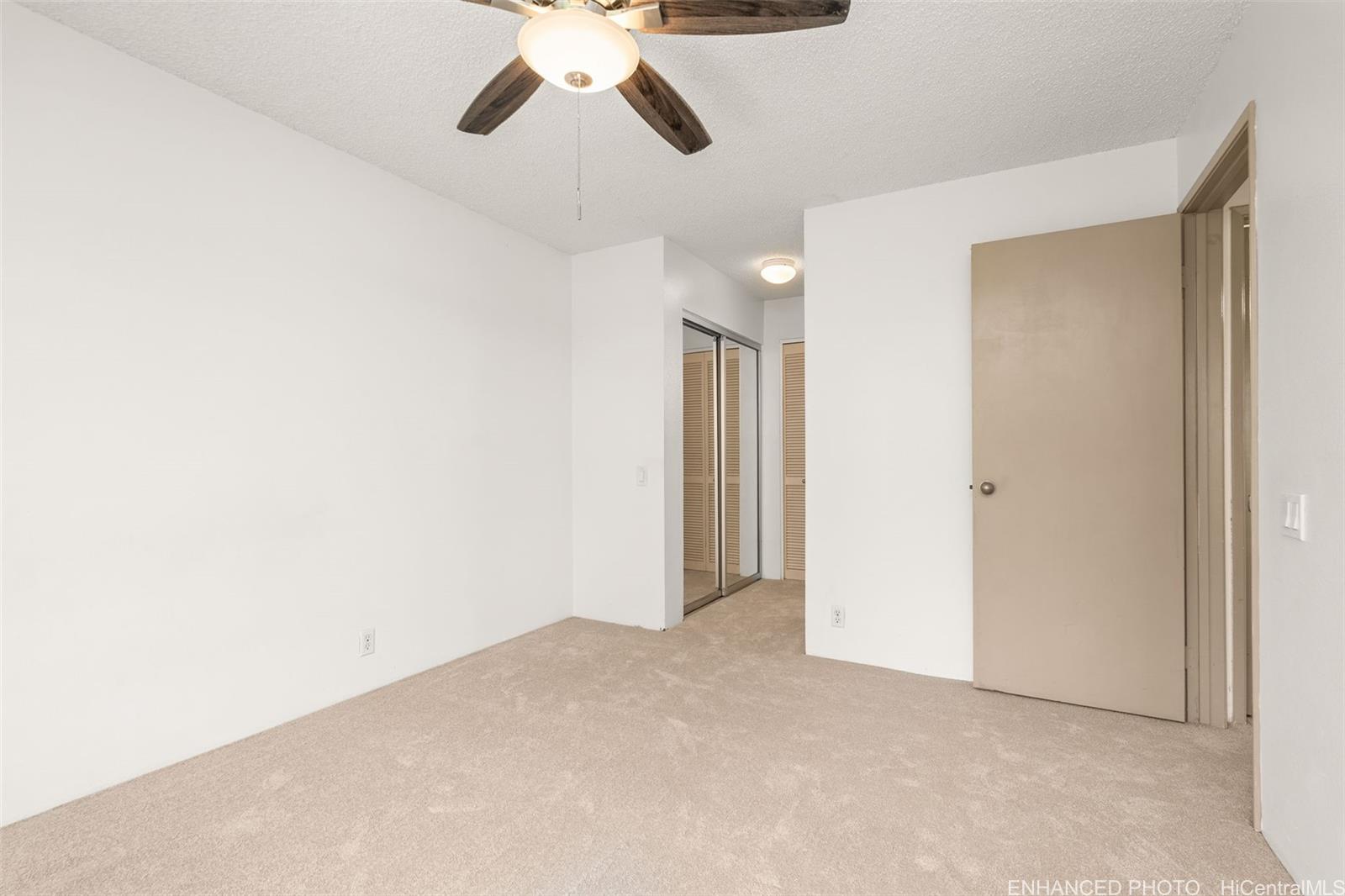 91-1119 Mikohu Street, Unit 28S Ewa Beach, HI 96706 - Photo 12 of 19 an empty room with chandelier fan