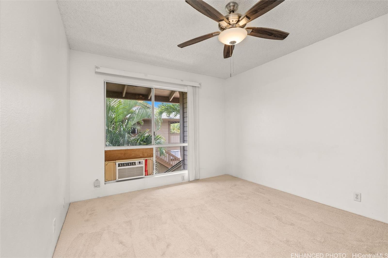 91-1119 Mikohu Street, Unit 28S Ewa Beach, HI 96706 - Photo 13 of 19 an empty room with windows chandelier fan