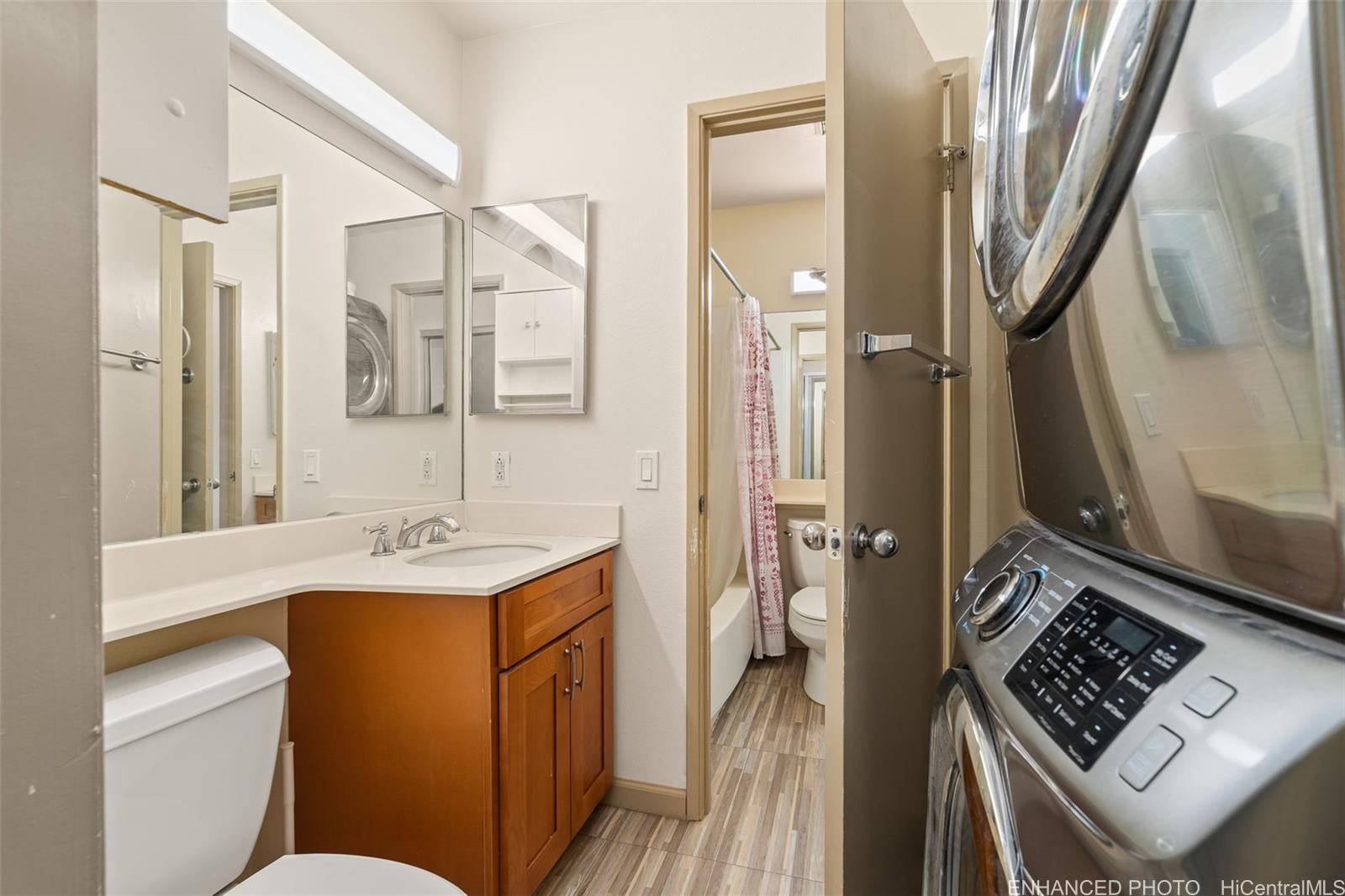 91-1119 Mikohu Street, Unit 28S Ewa Beach, HI 96706 - Photo 15 of 19 a bathroom with a toilet sink and mirror