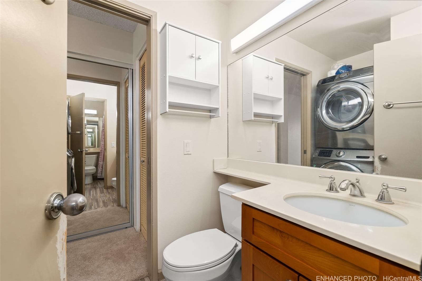 91-1119 Mikohu Street, Unit 28S Ewa Beach, HI 96706 - Photo 16 of 19 a bathroom with a sink a toilet and a mirror