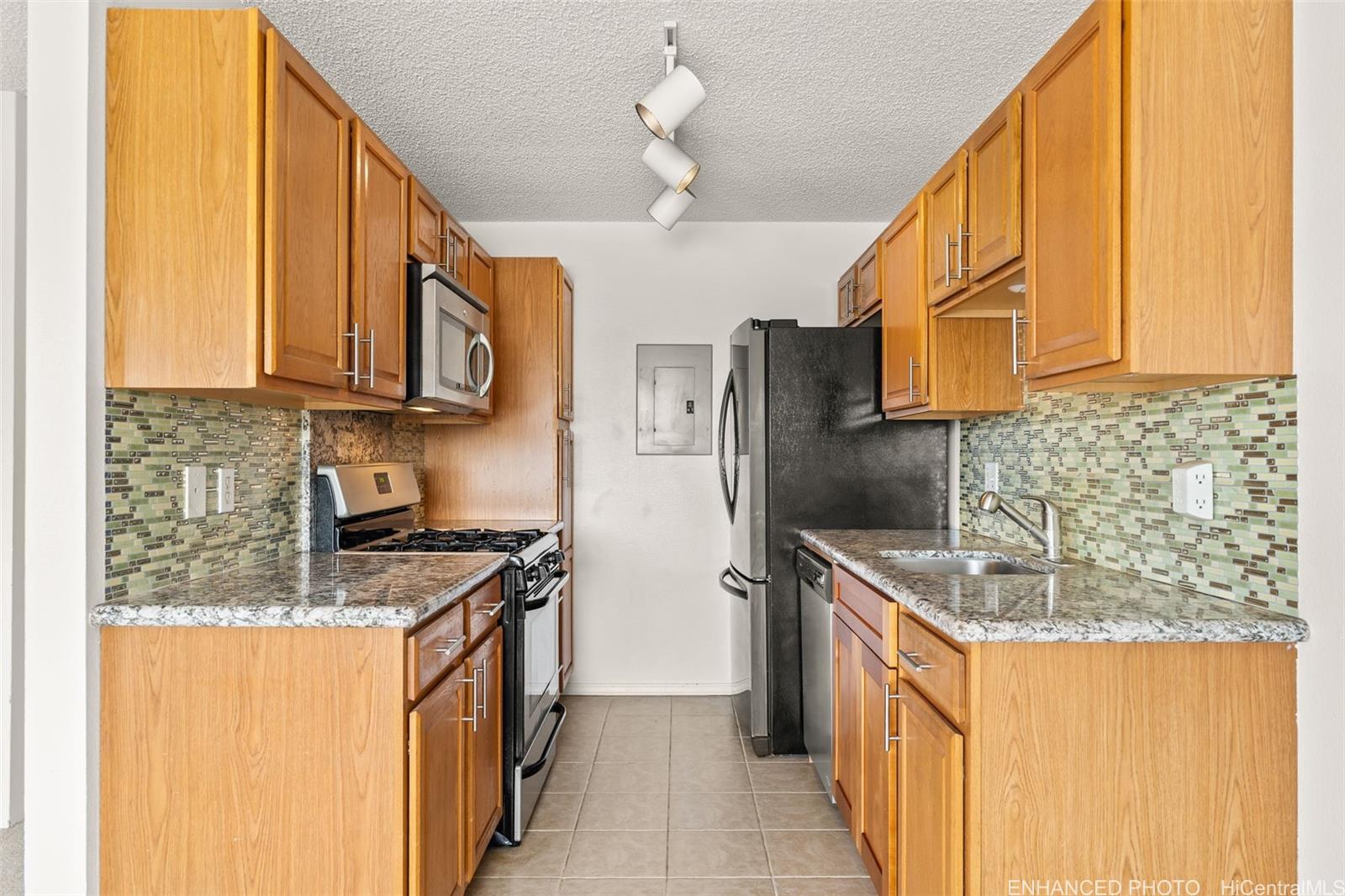 91-1119 Mikohu Street, Unit 28S Ewa Beach, HI 96706 - Photo 8 of 19 a kitchen with stainless steel appliances granite countertop a sink a stove and a refrigerator