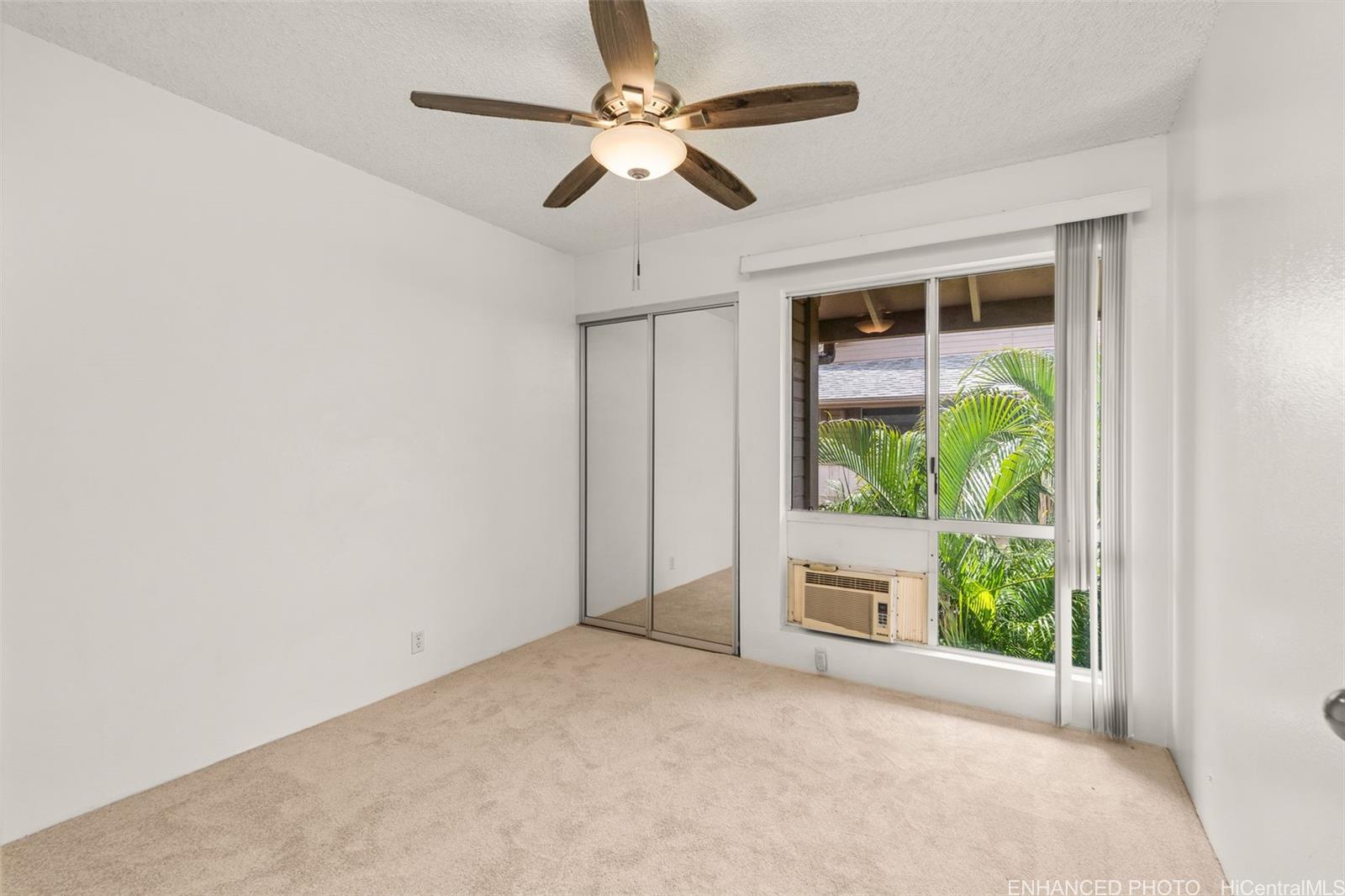 91-1119 Mikohu Street, Unit 28S Ewa Beach, HI 96706 - Photo 9 of 19 an empty room with windows and a ceiling fan