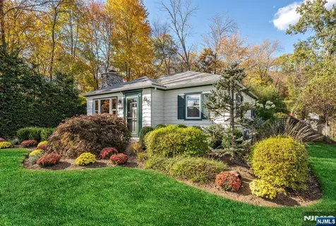 a front view of a house with a garden and plants