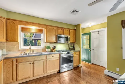 a kitchen with granite countertop a sink stainless steel appliances and cabinets