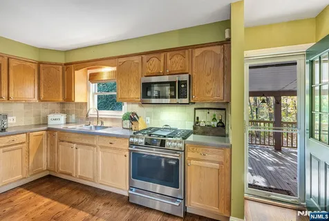 a spacious bedroom with a bed a dresser and flat screen tv