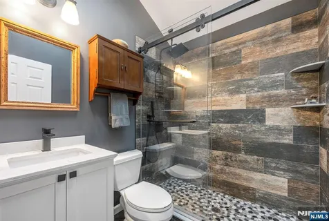 a bathroom with a sink and mirror with toilet