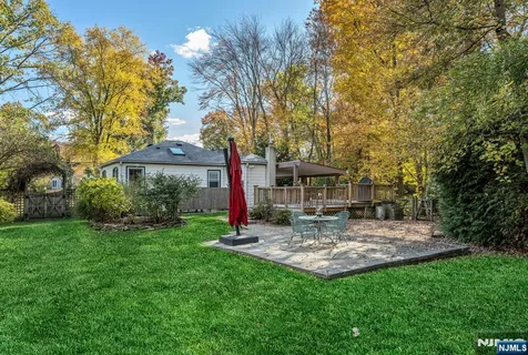 a view of a fountain in front of a house with large trees
