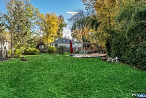 a front view of a house with garden and tree