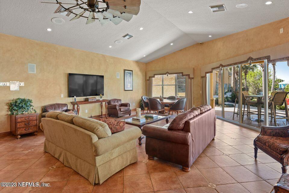 201 25th Avenue South, Unit N32 Jacksonville Beach, FL 32250 - Photo 26 of 38 a living room with furniture a flat screen tv and a chandelier