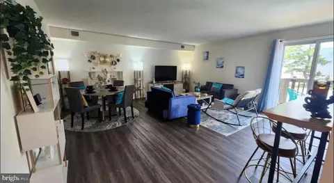 a living room with furniture a large window and a dining table