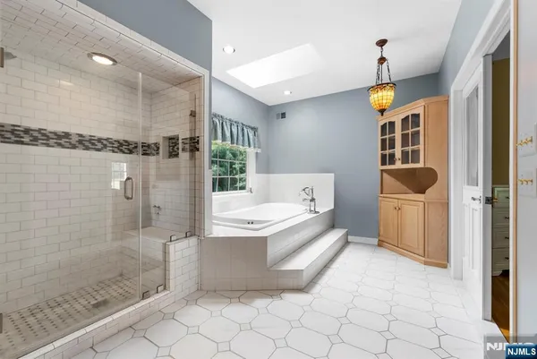 a bathroom with a tub sink shower and mirror