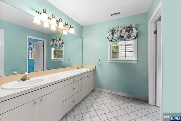 a spacious bathroom with a double vanity sink mirror and window