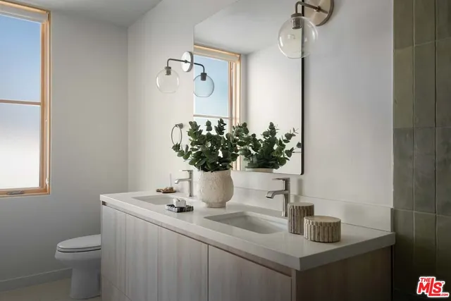 a bathroom with a sink a toilet and a mirror