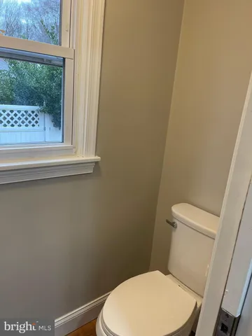 a white toilet sitting next to a small window