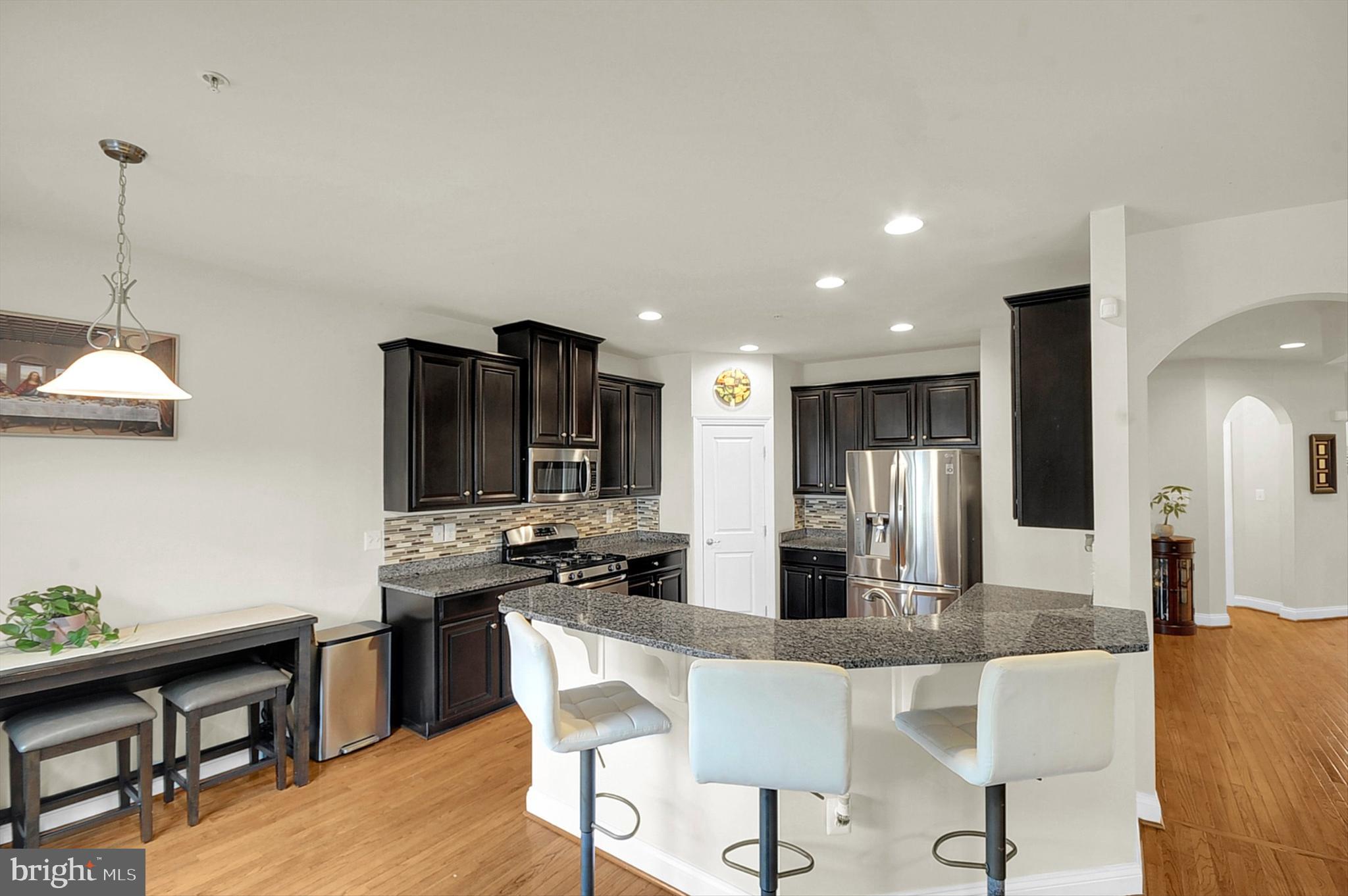 2405 Cindy Lane Warrington, PA 18976 - Photo 11 of 44 a kitchen with stainless steel appliances kitchen island granite countertop a dining table chairs and a refrigerator