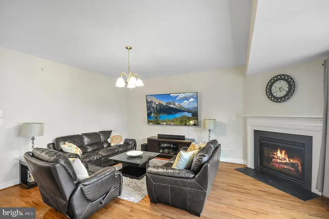 a living room with furniture a fireplace and a chandelier