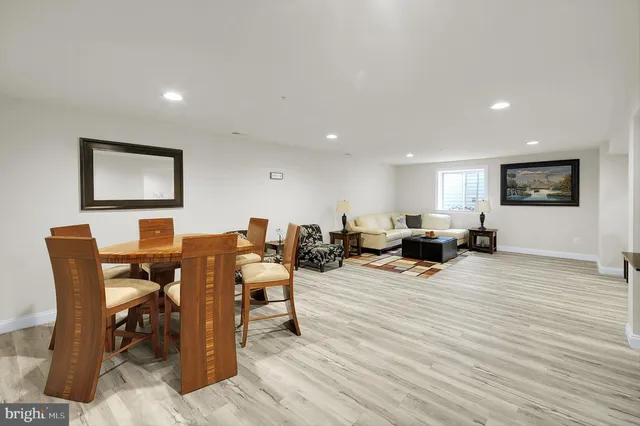 a living room with furniture a wooden floor and next to a window