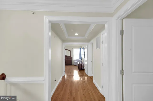 a view of a hallway with wooden floor and furniture