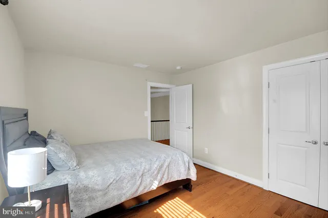a bedroom with a bed and a lamp on the dresser