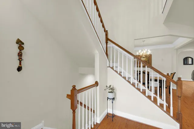 a view of staircase with lots of frames on wall and a window